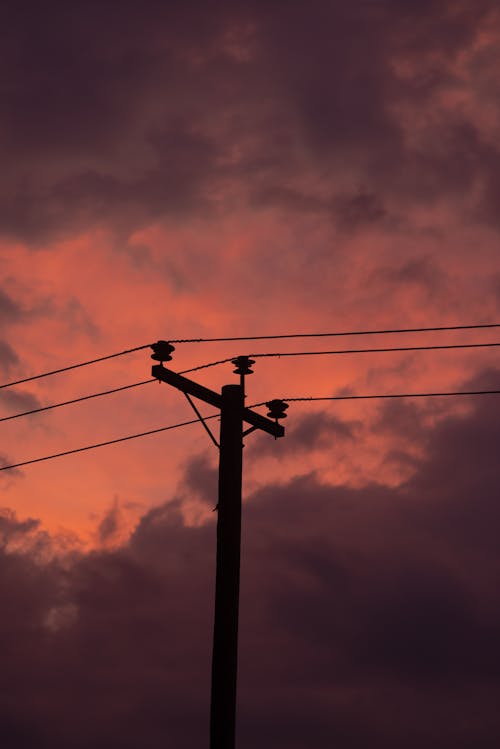 Photo of a Utility Pole Against a Red Sky