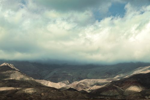 Free Breathtaking view of a rocky desert landscape with dramatic cloud cover and soft natural lighting. Stock Photo