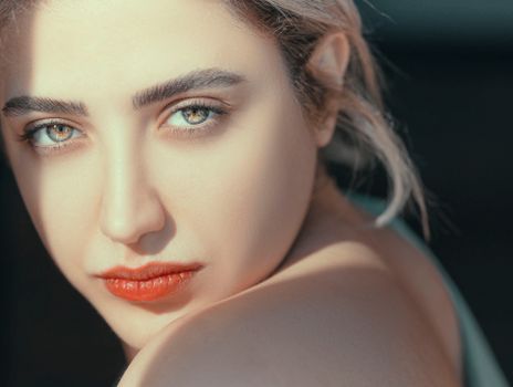 Intimate close-up of a woman with captivating eyes and natural lighting.
