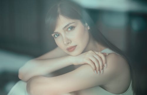 Photo of a Beautiful Young Woman Sitting Outside the Window