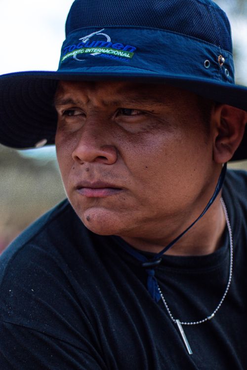 Free Portrait of a serious man wearing a blue fishing hat, outdoors, with a pensive expression. Stock Photo