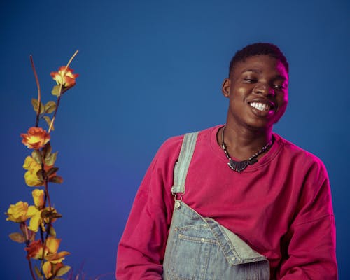 Man Smiling next to Flower