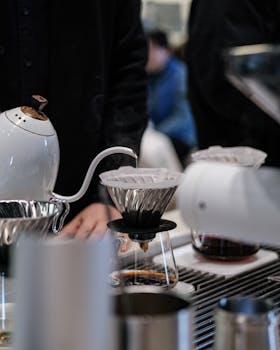 Close-up of artisan coffee brewing setup with drip coffee maker in a modern cafe setting.