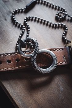 Close-up of a handmade octopus tentacle pendant resting on a leather strap.