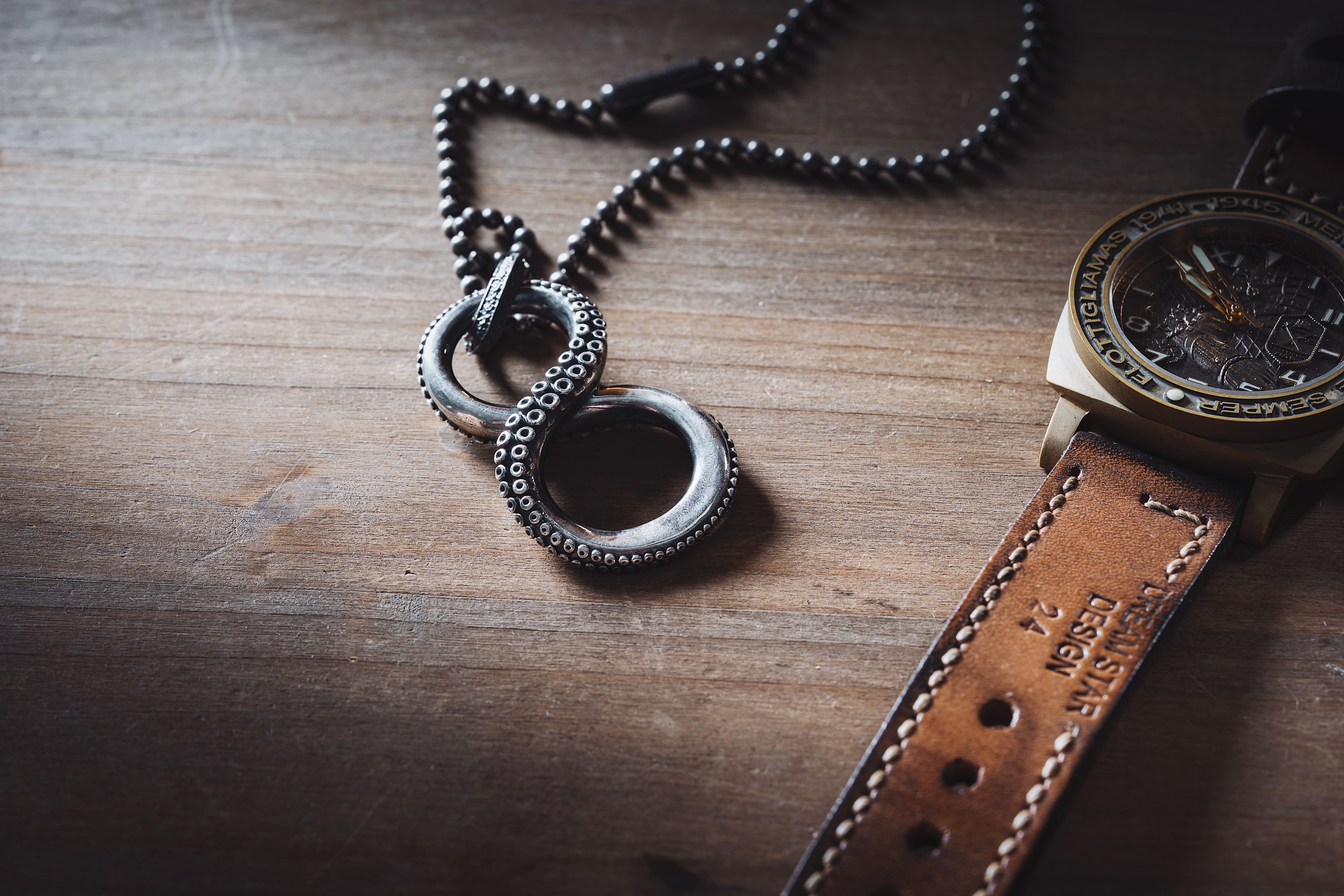 Neck Chain by Wristwatch on Table · Free Stock Photo