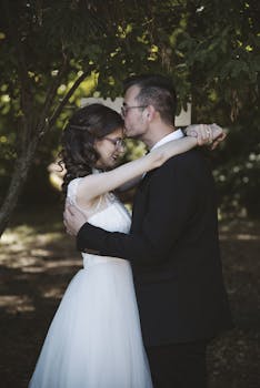 在阳光明媚的户外婚礼上，欢乐的新娘和新郎相拥，四周环绕着大自然