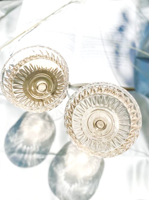 Free Top-down view of ornate crystal glasses casting shadows on a sunlit surface. Stock Photo