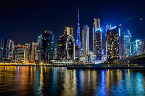 Illuminated Skyscrapers in Waterfront City at Night