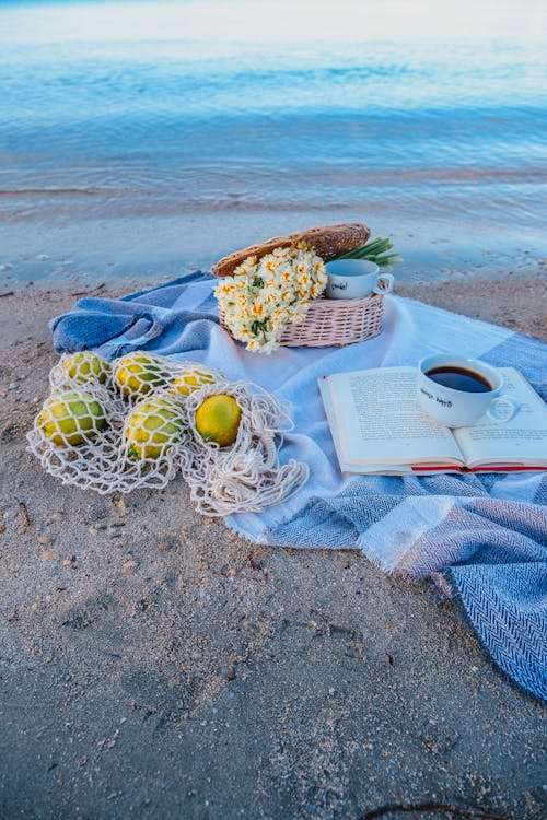 Photo of a Blanket with Items on a Beach