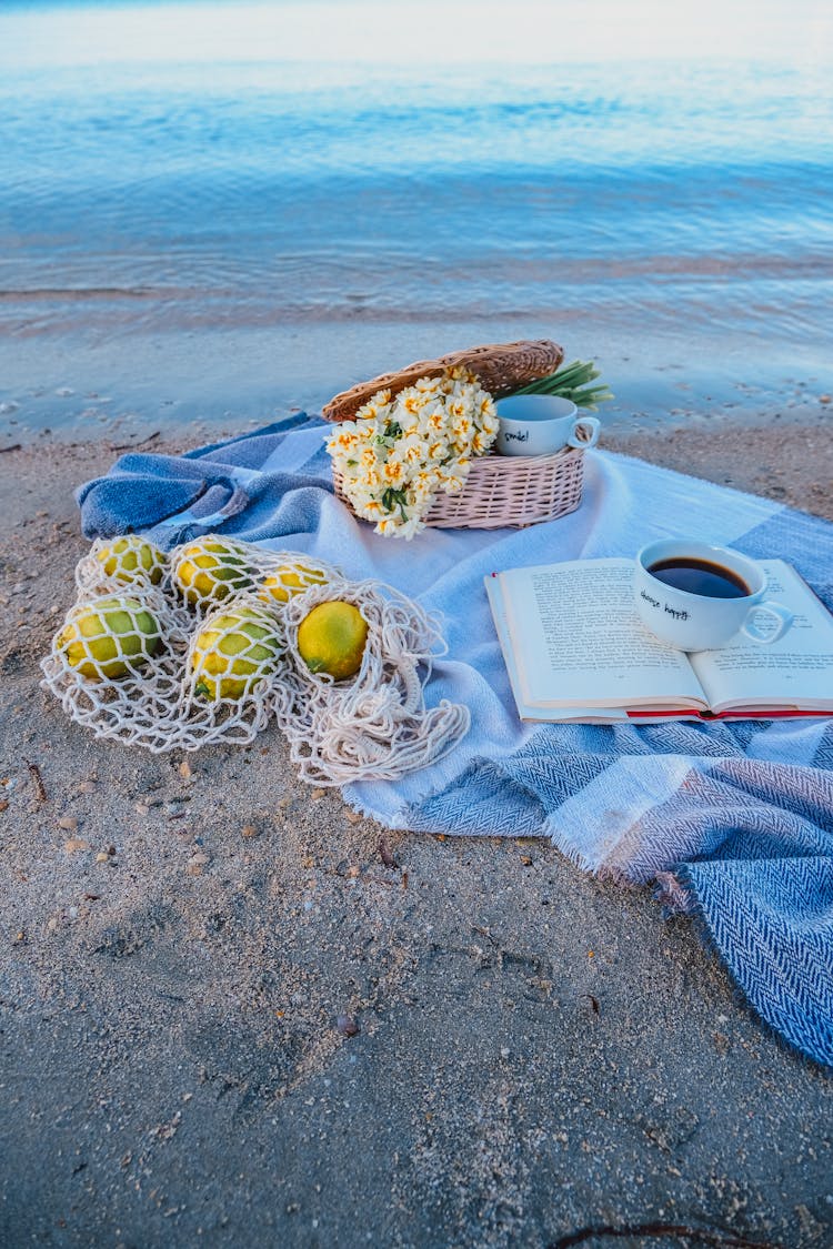 Photo Of A Blanket With Items On A Beach