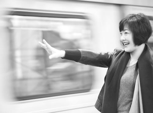 Grayscale Photography of Woman Raising Right Arm