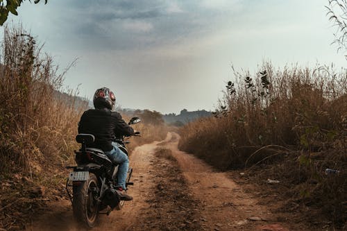 Man on a Motorbike on an Unpaved Road 