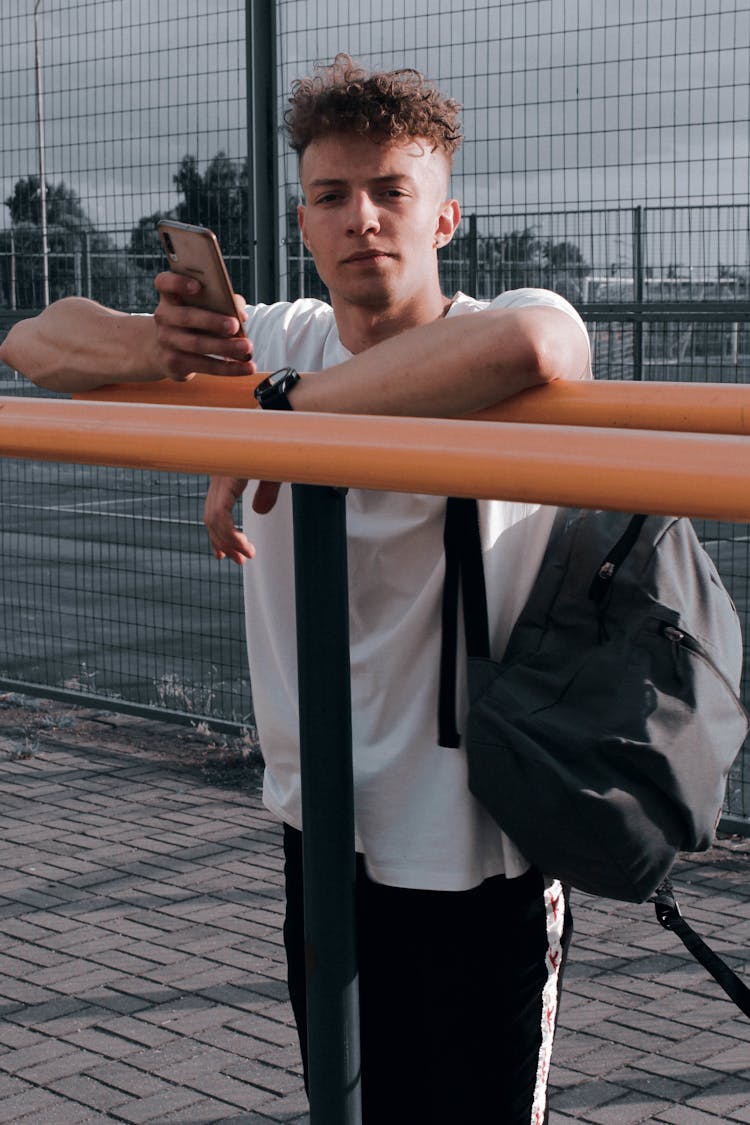 Man With Backpack And Phone Posing Near Sport Bars