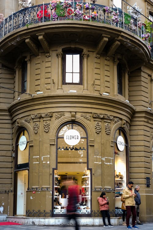 Free People near Building with Flowers on Balcony Stock Photo