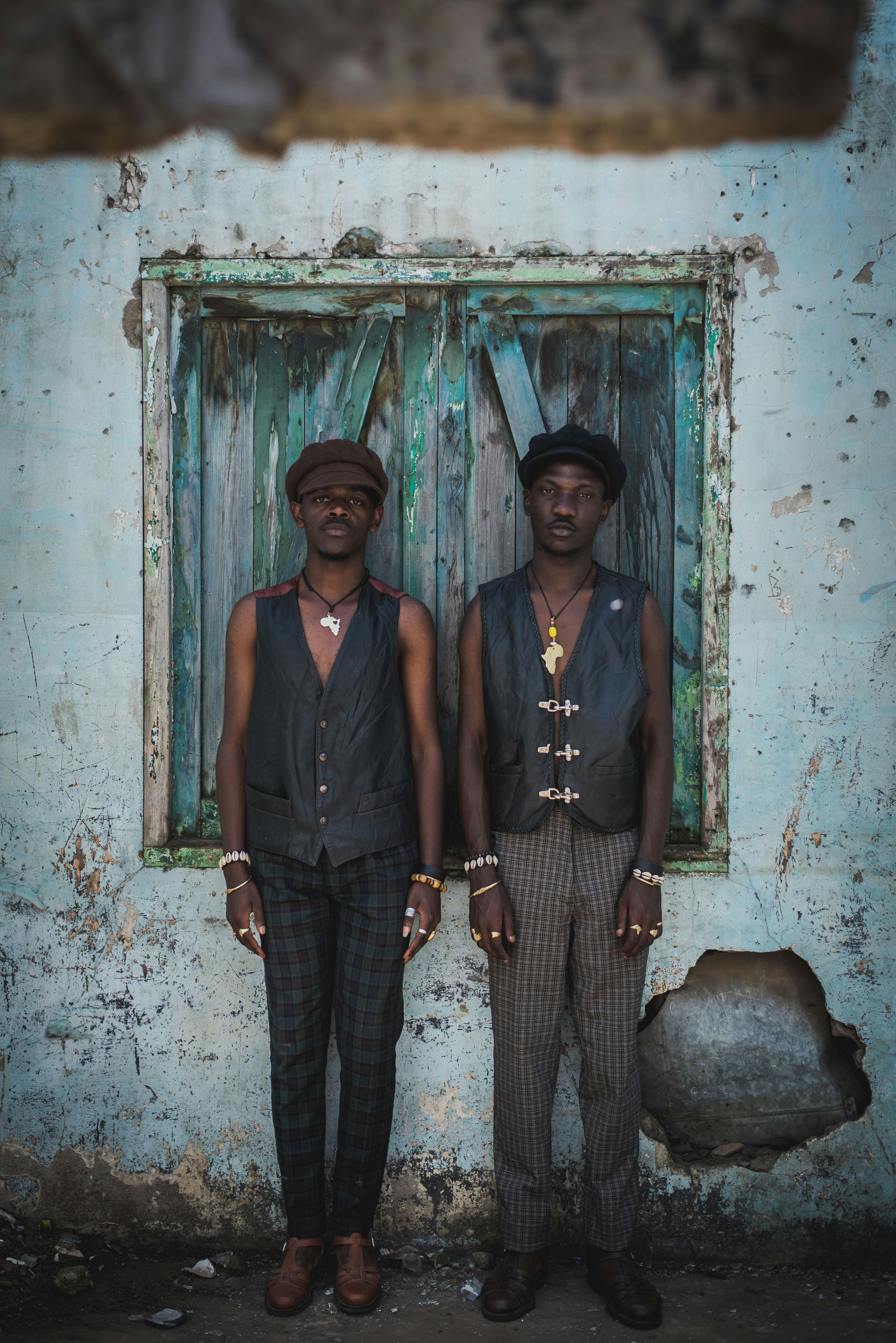 two men stand in front of a blue window