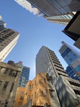 Dynamic cityscape with towering skyscrapers under a bright clear blue sky, emphasizing urban architecture.