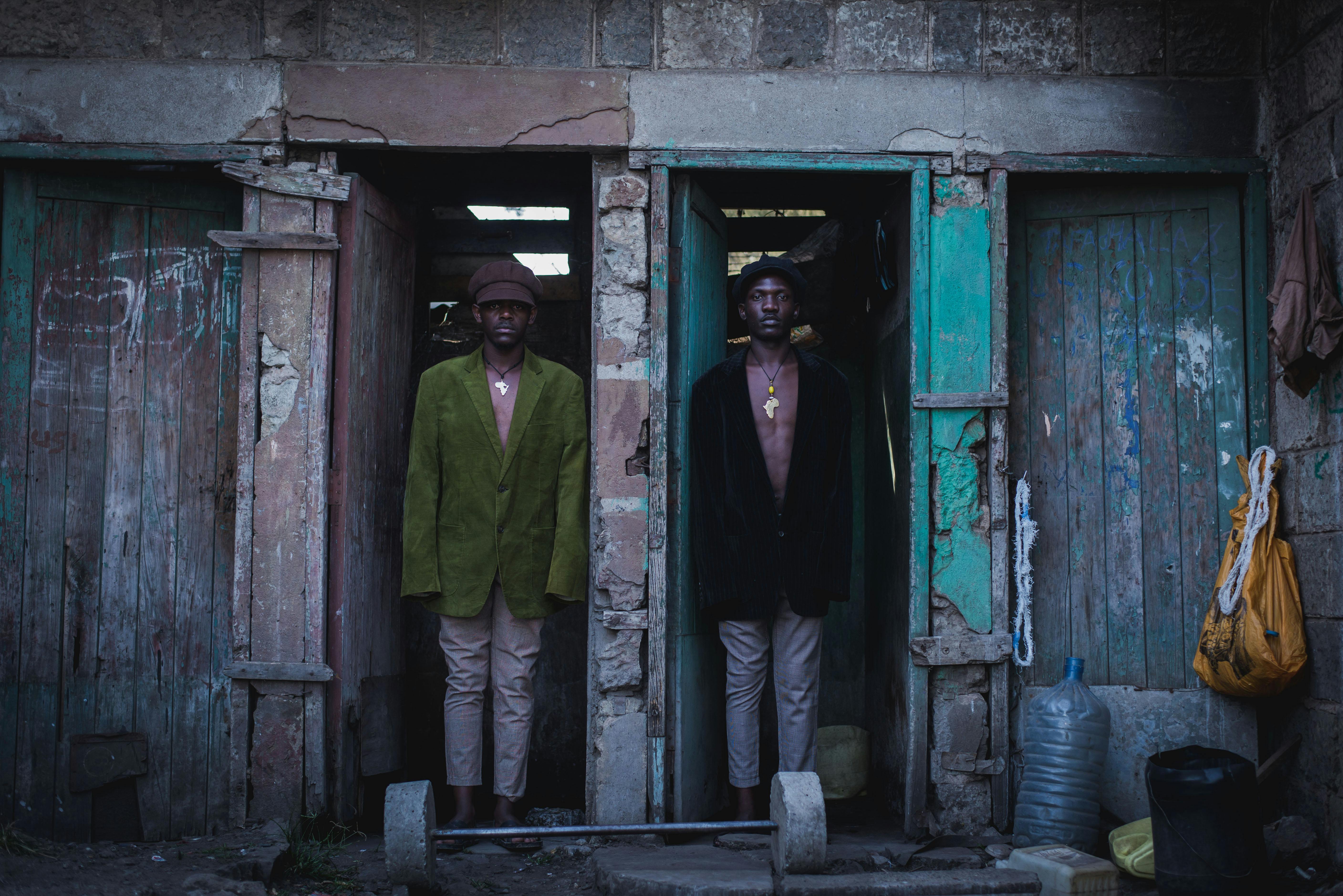 two men stand in front of a door with a sign on it