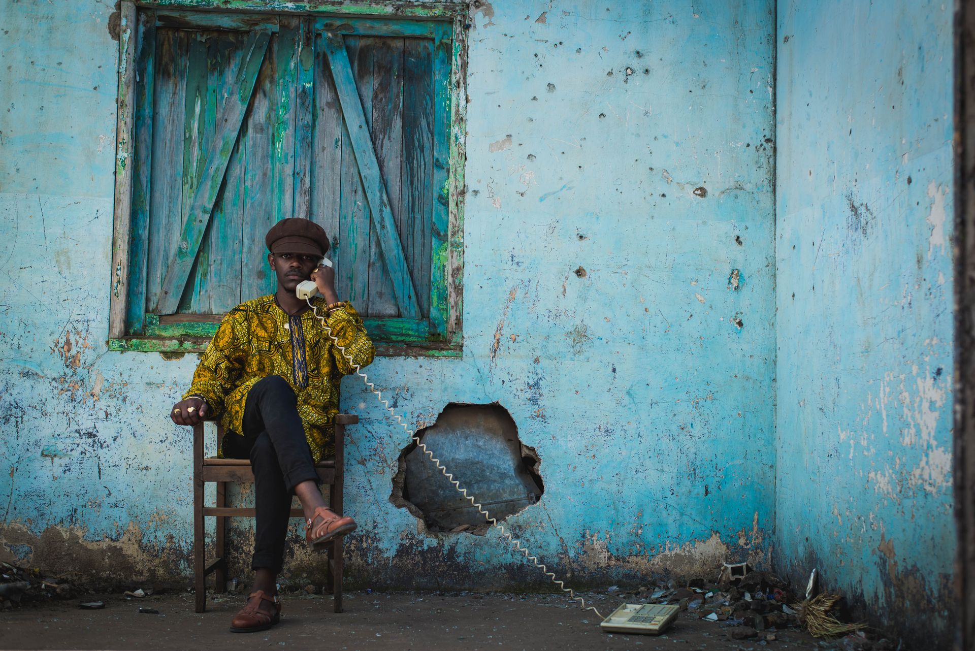 A man sitting on a chair talking on a phone