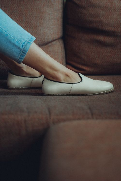 Free Close-up of stylish woman's legs in elegant shoes resting on a textured couch, showcasing fashion and comfort. Stock Photo