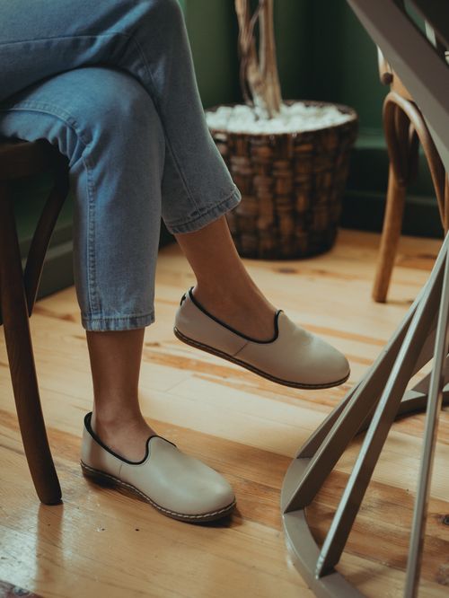Free Closeup of elegant beige shoes paired with jeans on a wooden floor setting indoors. Stock Photo