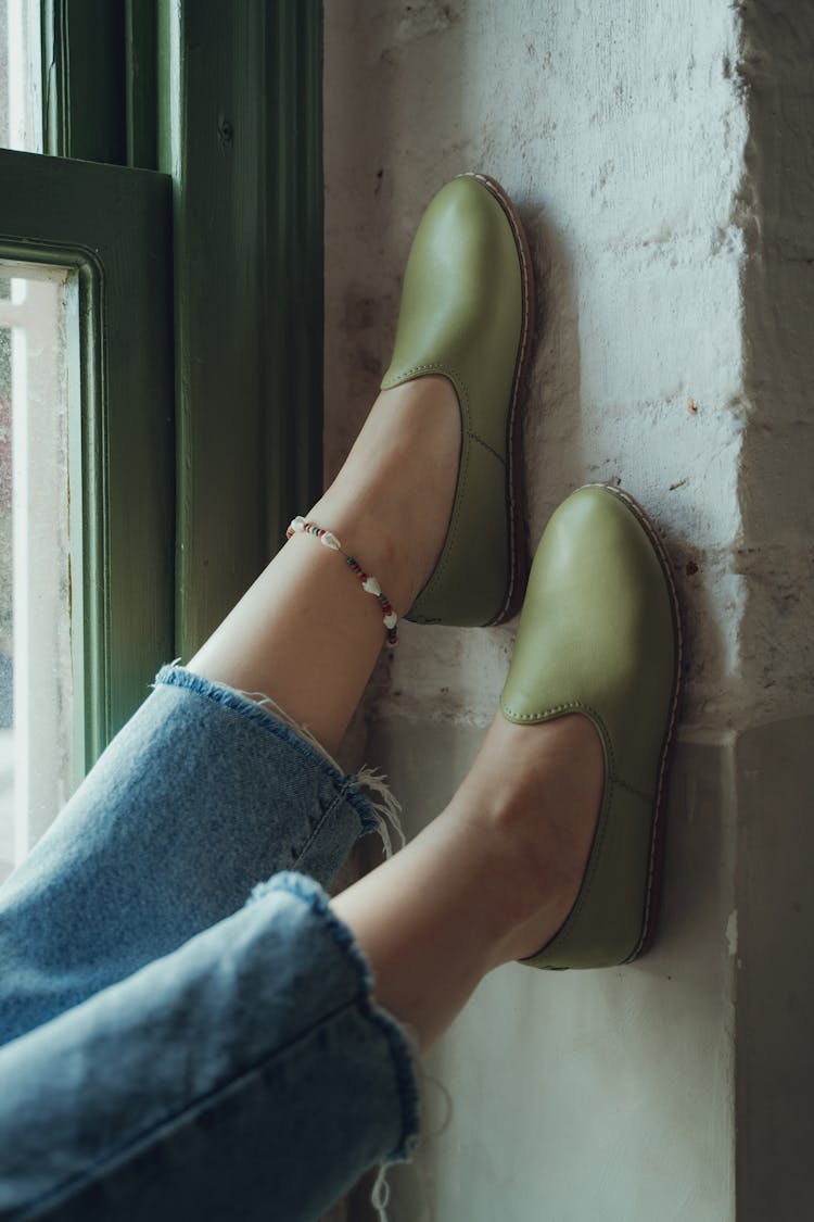 Legs With Green Shoes Leaning On Wall