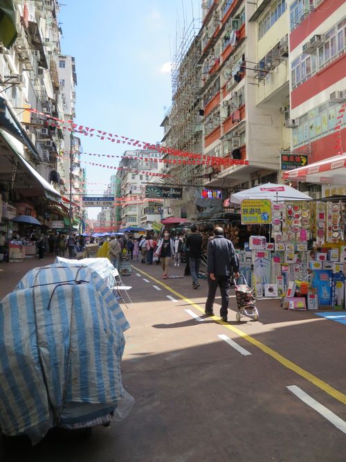 Free Vibrant market street in Hong Kong city bustling with shoppers and vendors. Stock Photo