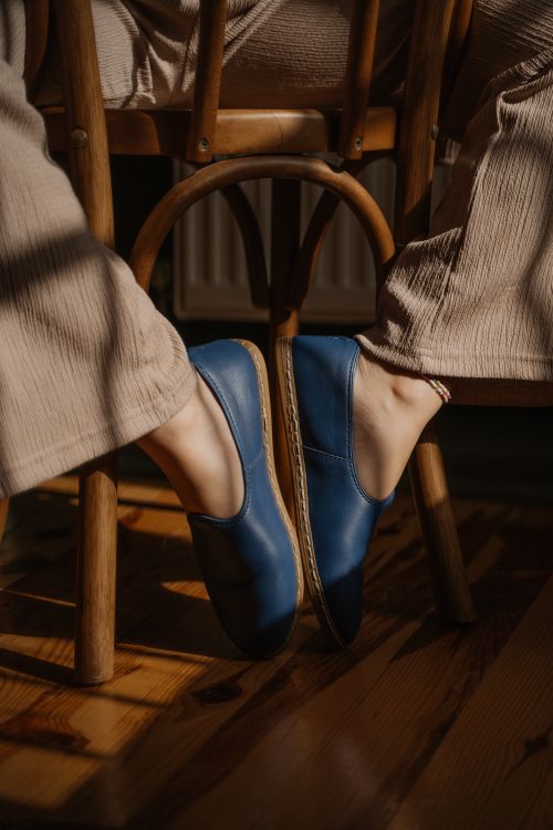 Free Casual blue leather shoes under wooden chair, indoors lighting highlight fashion details. Stock Photo