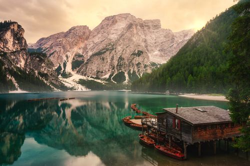 Free A breathtaking view of Lake Braies reflecting the Dolomite mountains at sunset. Stock Photo
