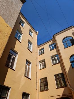 Explore this low angle view of a classic urban residential building facade against a clear blue sky.
