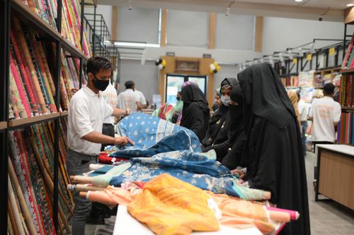 Free Women selecting colorful textiles in a fabric store, highlighting cultural attire. Stock Photo