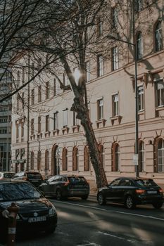 A moody urban street with parked cars and historic architecture in Budapest.