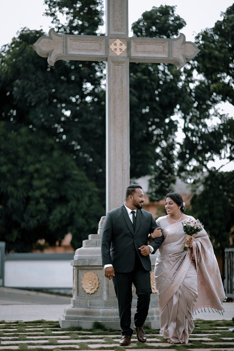 Smiling Bride And Groom Walking Outside Church