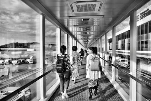 Grayscale Photo of Woman Walking on Pathway