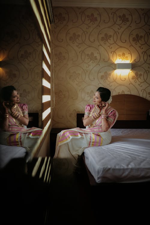 A Young Woman in a Sari is Sitting on the Bed