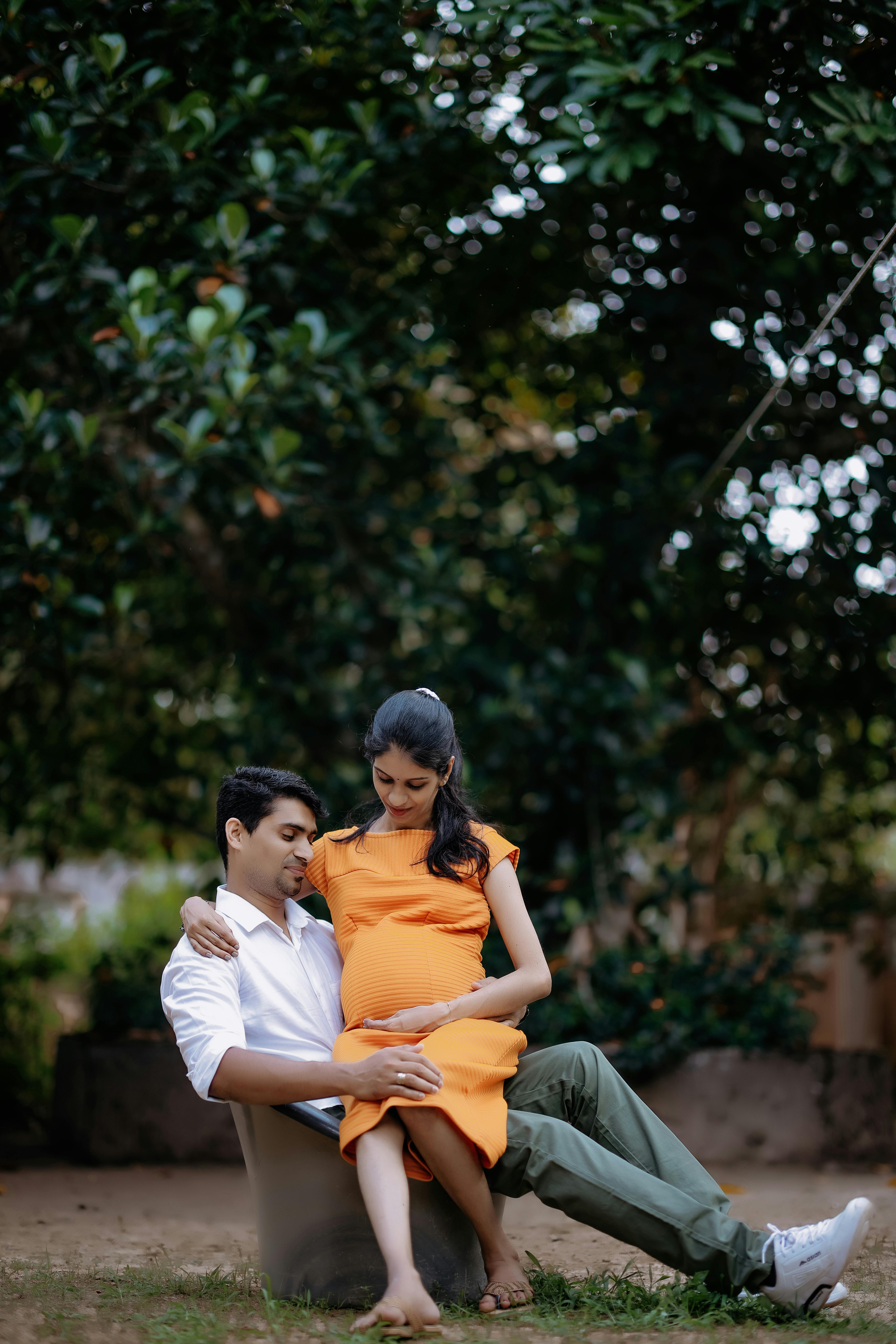 Pregnant Woman Sitting on Her Partners Lap · Free Stock Photo