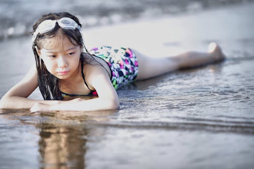 Selective Color Photography of Girl Lying on Beach