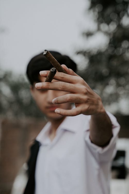 Man Holding Two Cigars