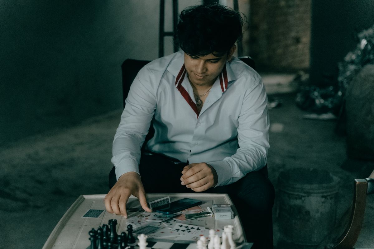 A thoughtful chess player at a wooden table