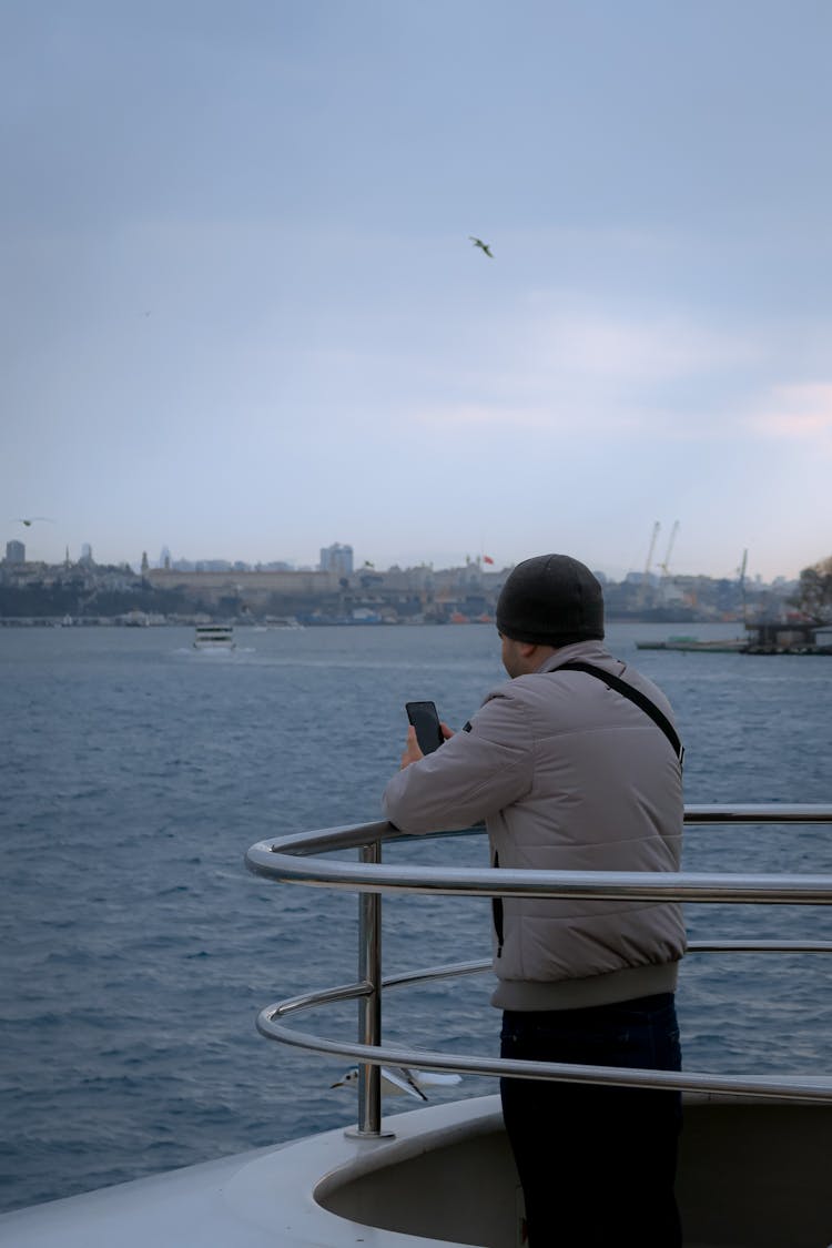 Man Checking His Phone On The Boat 