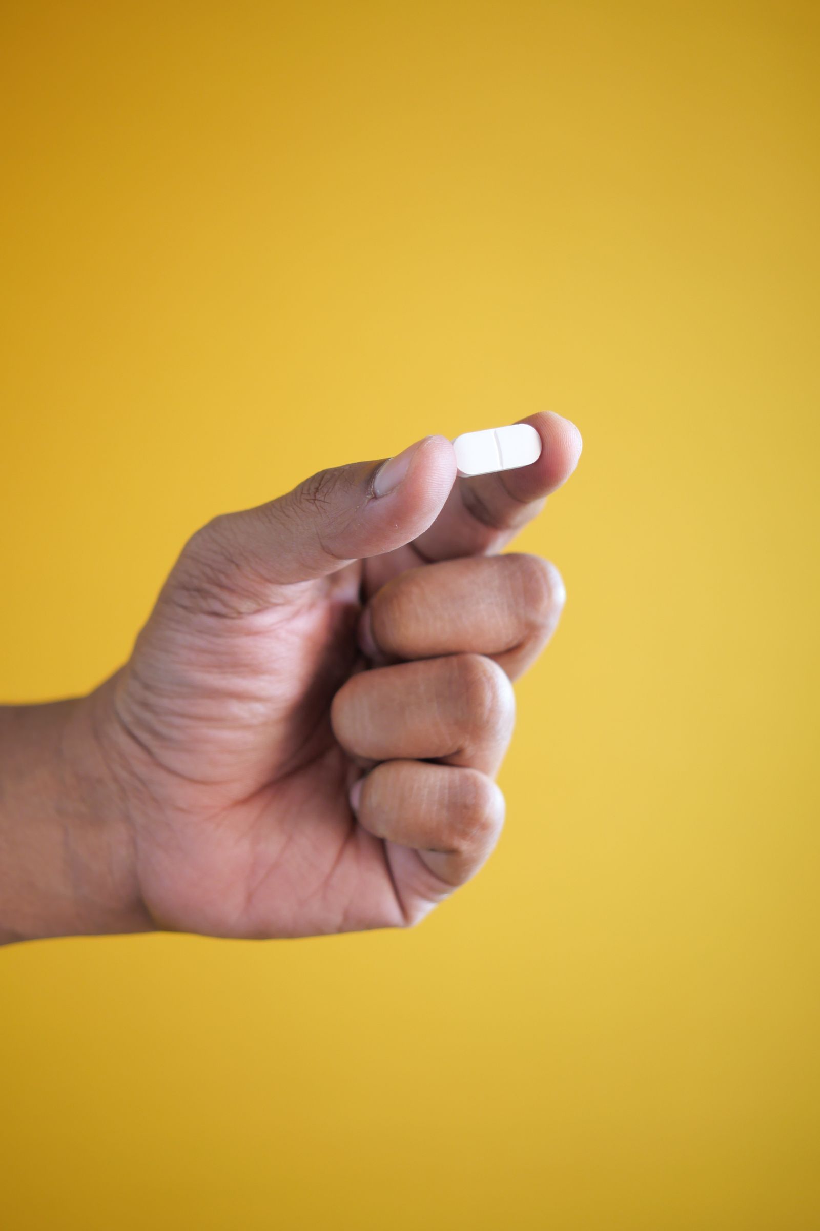 A single daily weight-loss tablet held in the hand