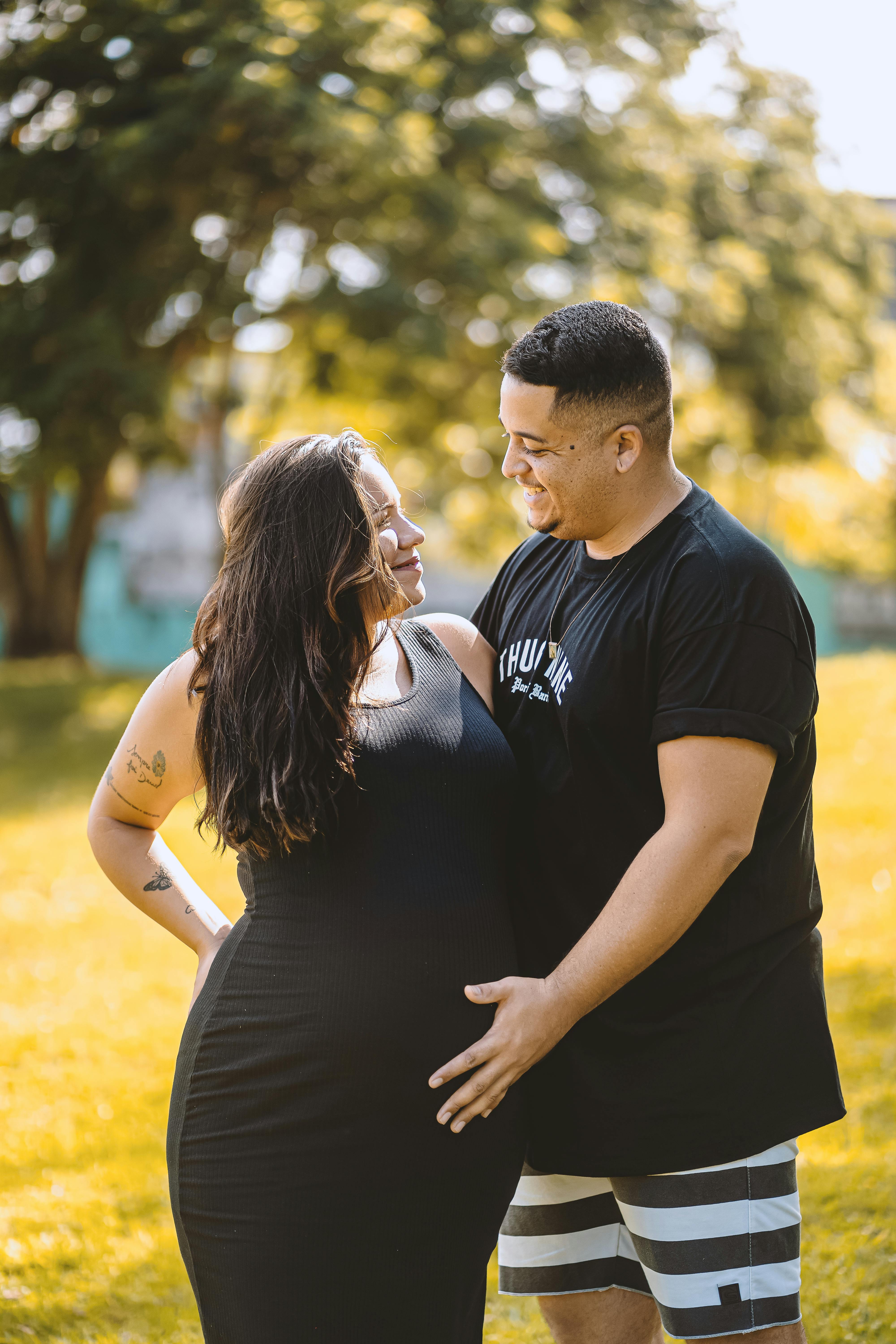 man standing with his hand on the belly of his pregnant wife