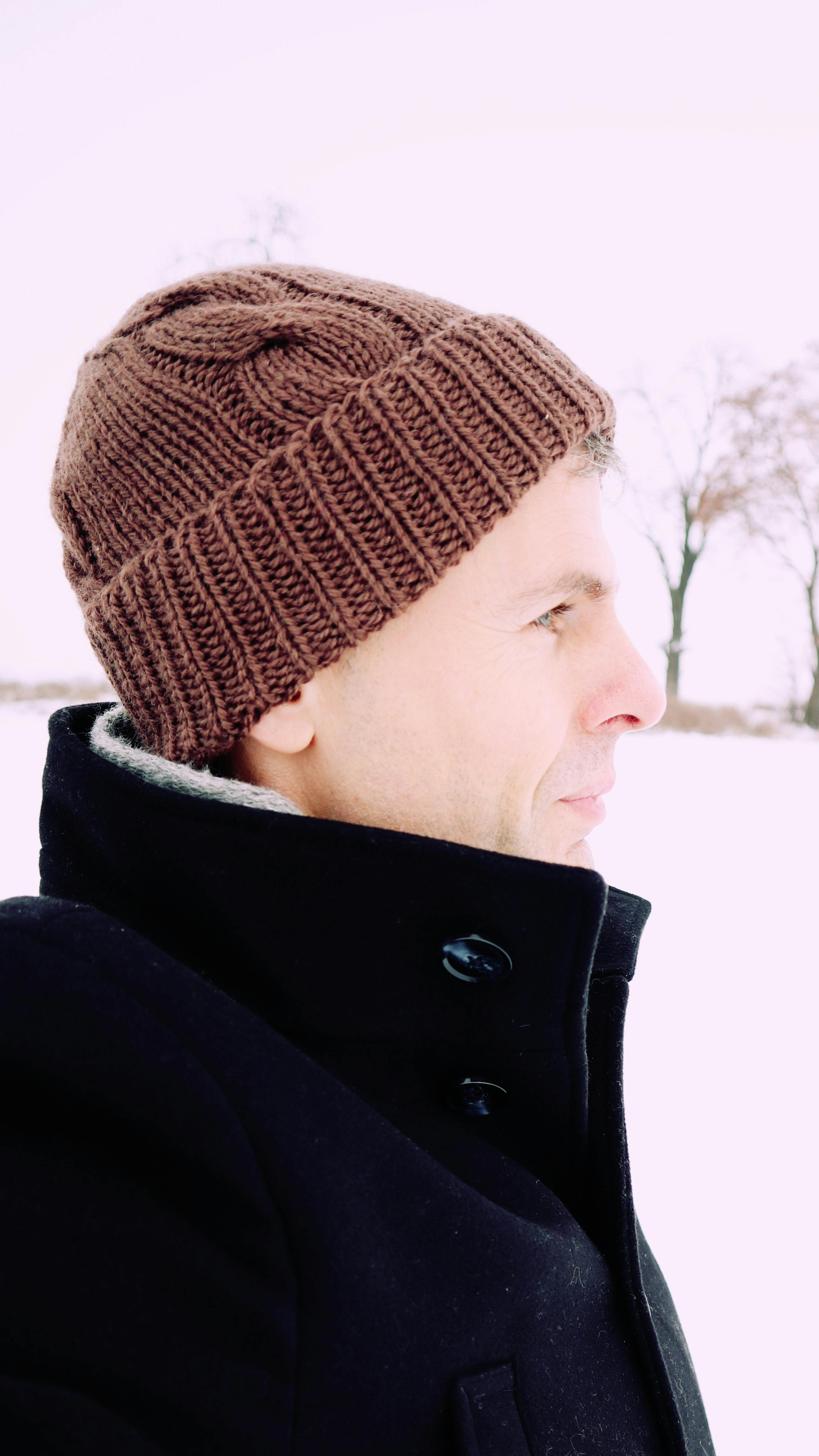 Profile portrait of a man wearing a woolen hat in snowy Wrocław.