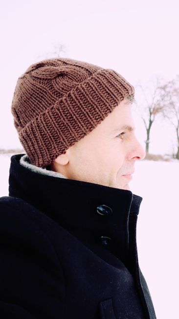 Profile portrait of a man wearing a woolen hat in snowy Wrocław.
