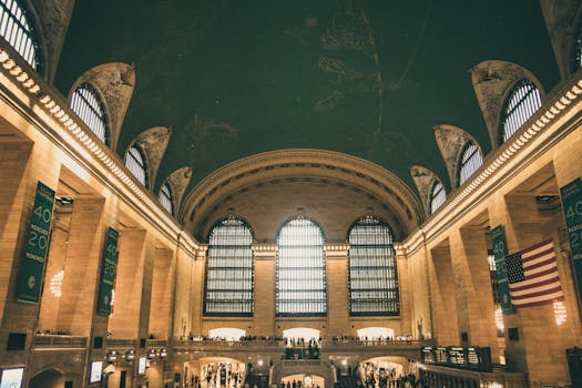 Stunning view of Grand Central Terminal's iconic interior with American flag and arched windows.