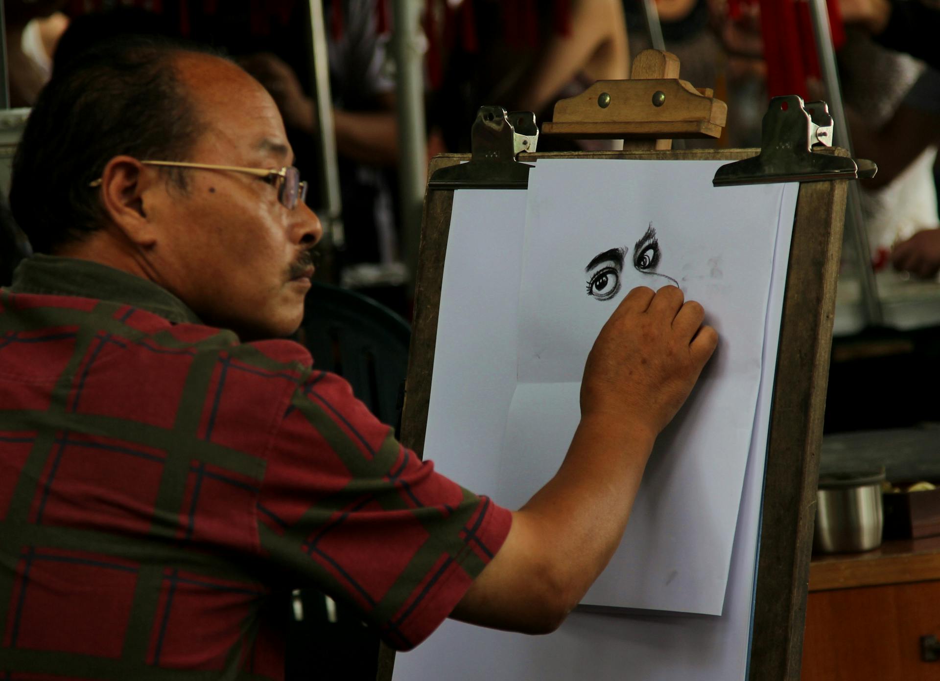 An artist skillfully drawing a portrait outdoors in Hangzhou, Zhejiang Province, China.