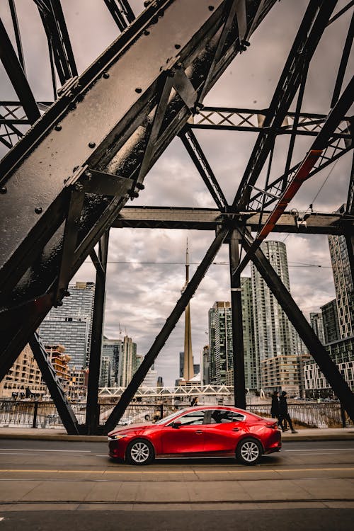 Foto profissional grátis de arranha-céus, automóvel, carro vermelho