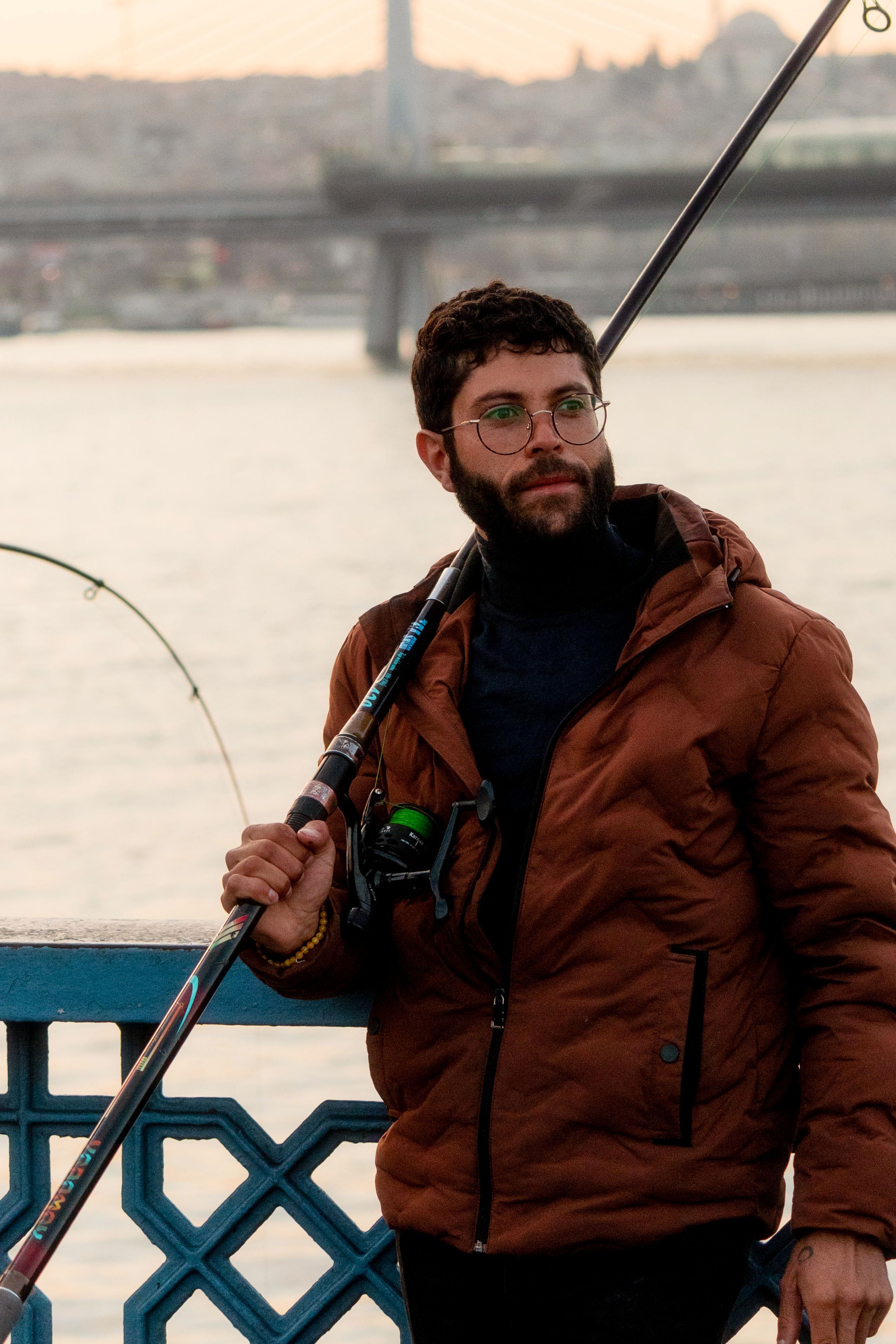 A young man enjoys fishing by the Bosphorus Bridge in Istanbul, Turkey.
