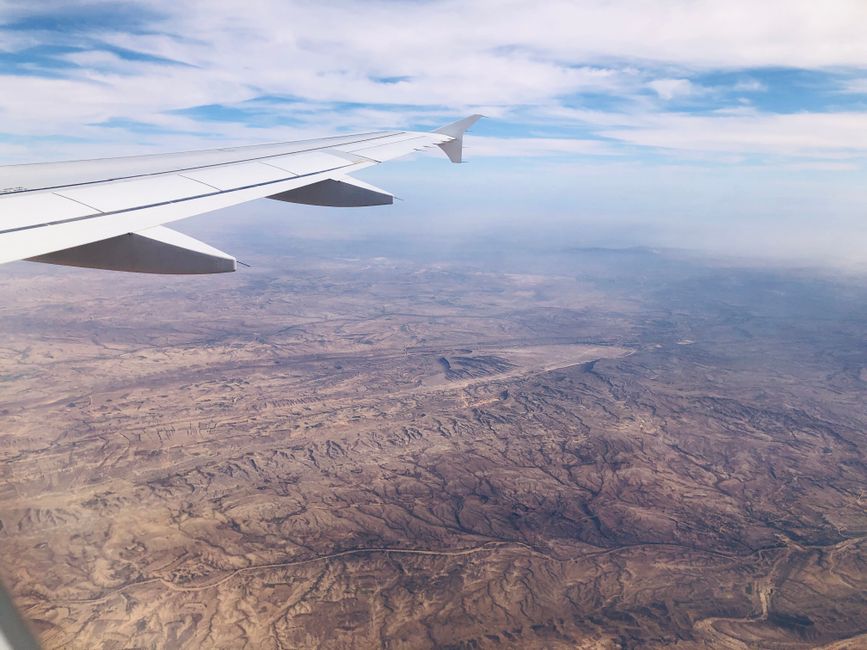 Saudia aircraft flying over the desert landscape of Saudi Arabia