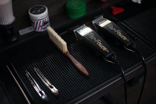 Close-up of hair clippers and grooming tools in a modern barbershop setup.