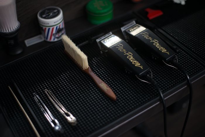Barber clippers and tools laid out on the mat
